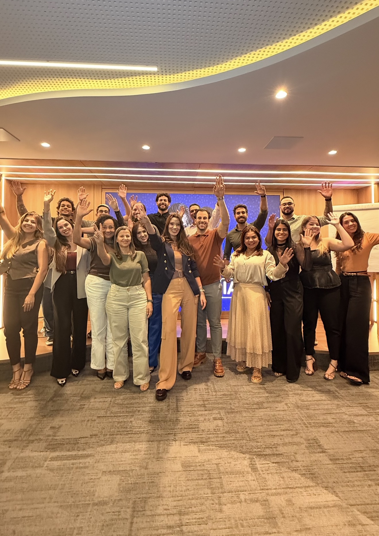 Grupo de participantes acenando ao final de treinamento com Malu Albuquerque